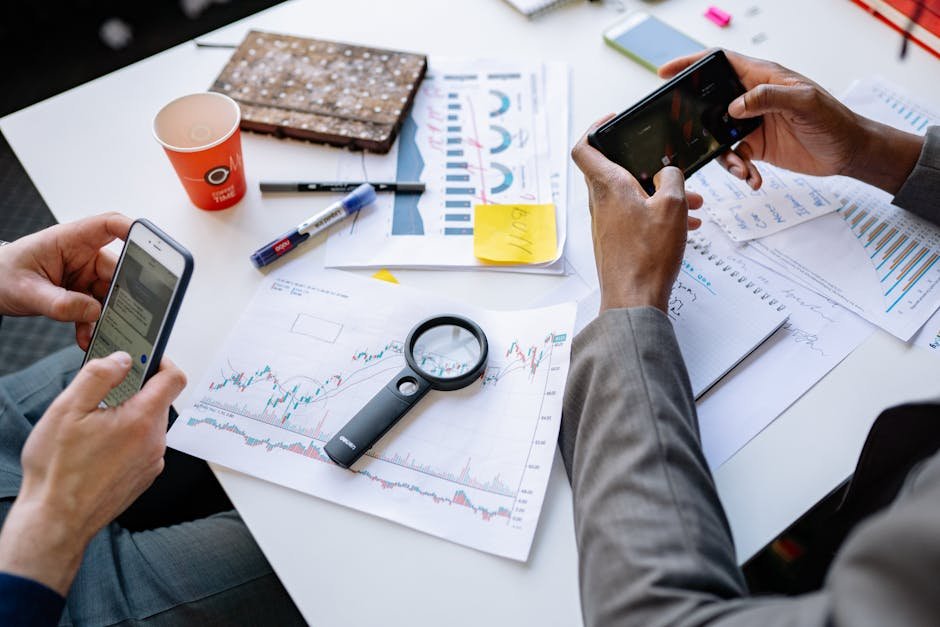 pexels-photo-7793694-7793694 Two professionals analyzing data and graphs with smartphones on a white table.