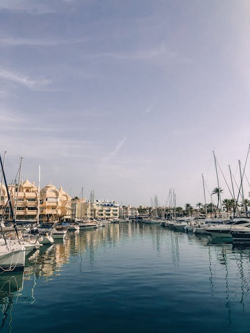 Calm marina scene in Benalmádena, Spain, showcasing moored yachts and waterfront architecture.