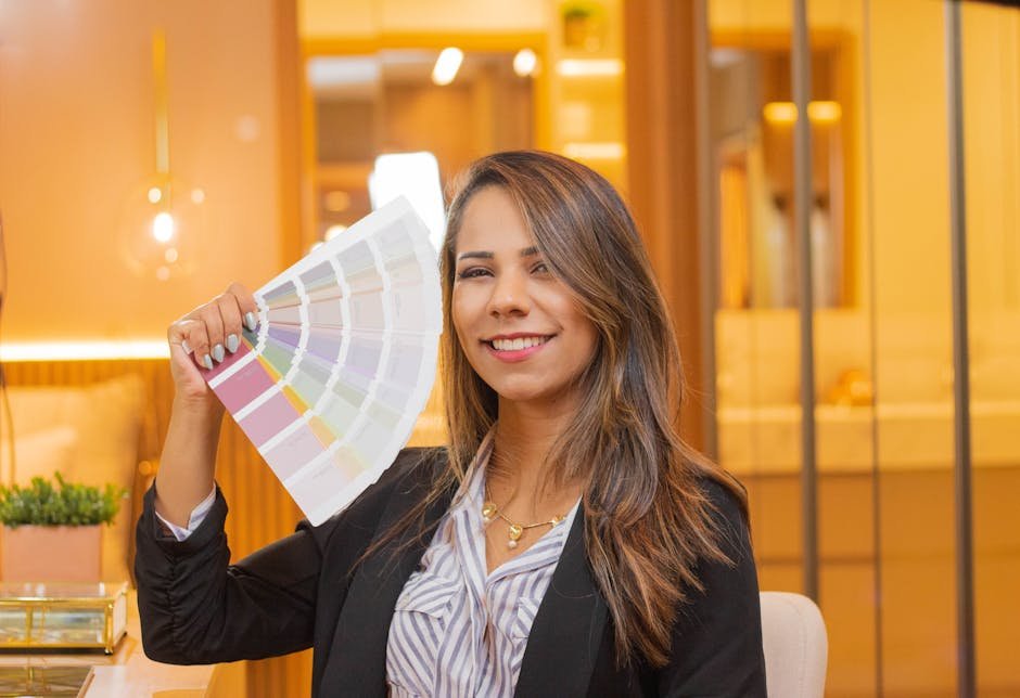 Portrait of a confident businesswoman in a black blazer holding color swatches indoors.