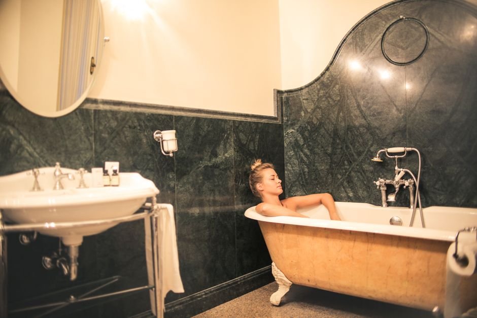A serene moment of relaxation in an elegant marble bathroom with a vintage bathtub.